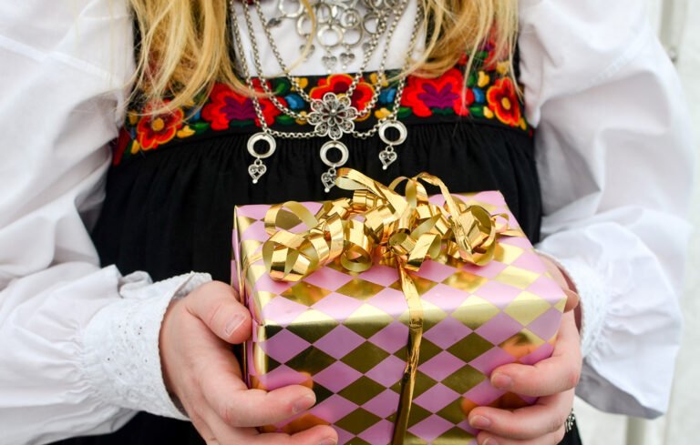 Norwegian woman in bunad carrying a gift.