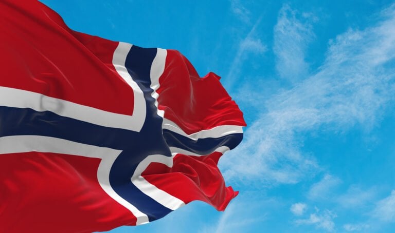 Norwegian flag against a blue sky.