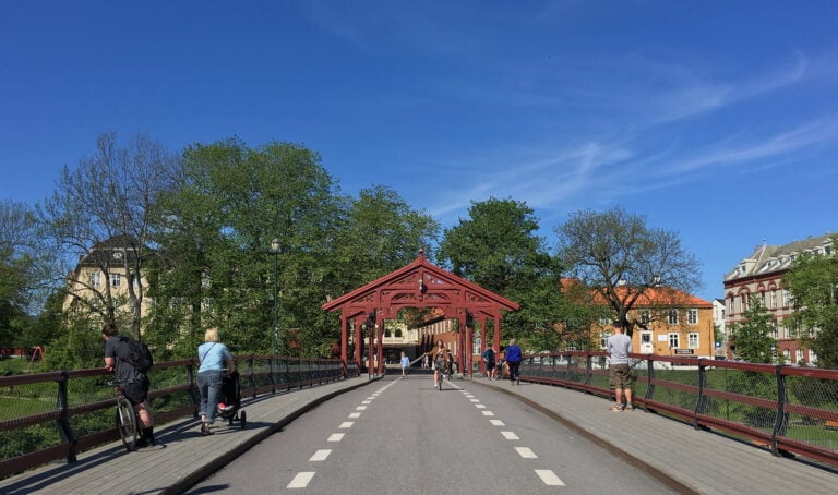 People walking on an old bridge in Trondheim, Norway.
