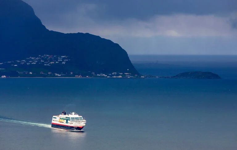 Hurtigruten vessel near shoreline in Norway.