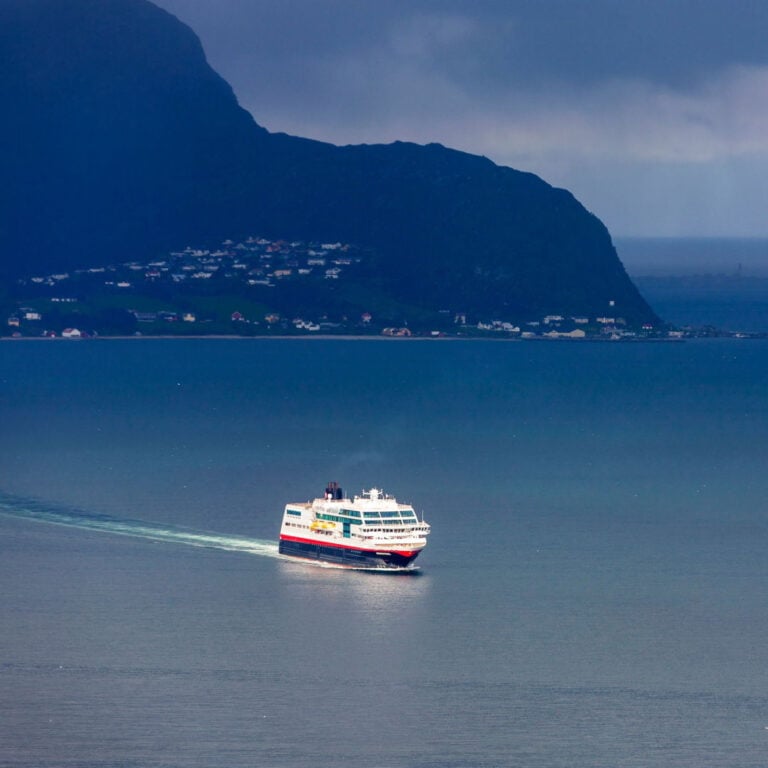 Hurtigruten ship sailing along the Norwegian coastline.