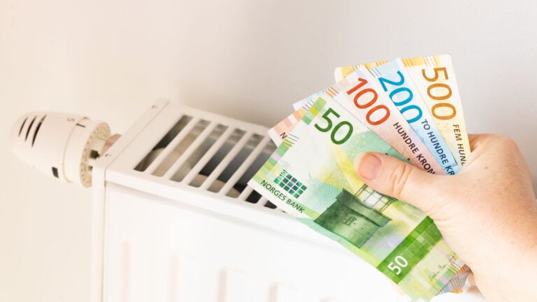 Norwegian krone banknotes in front of a radiator.