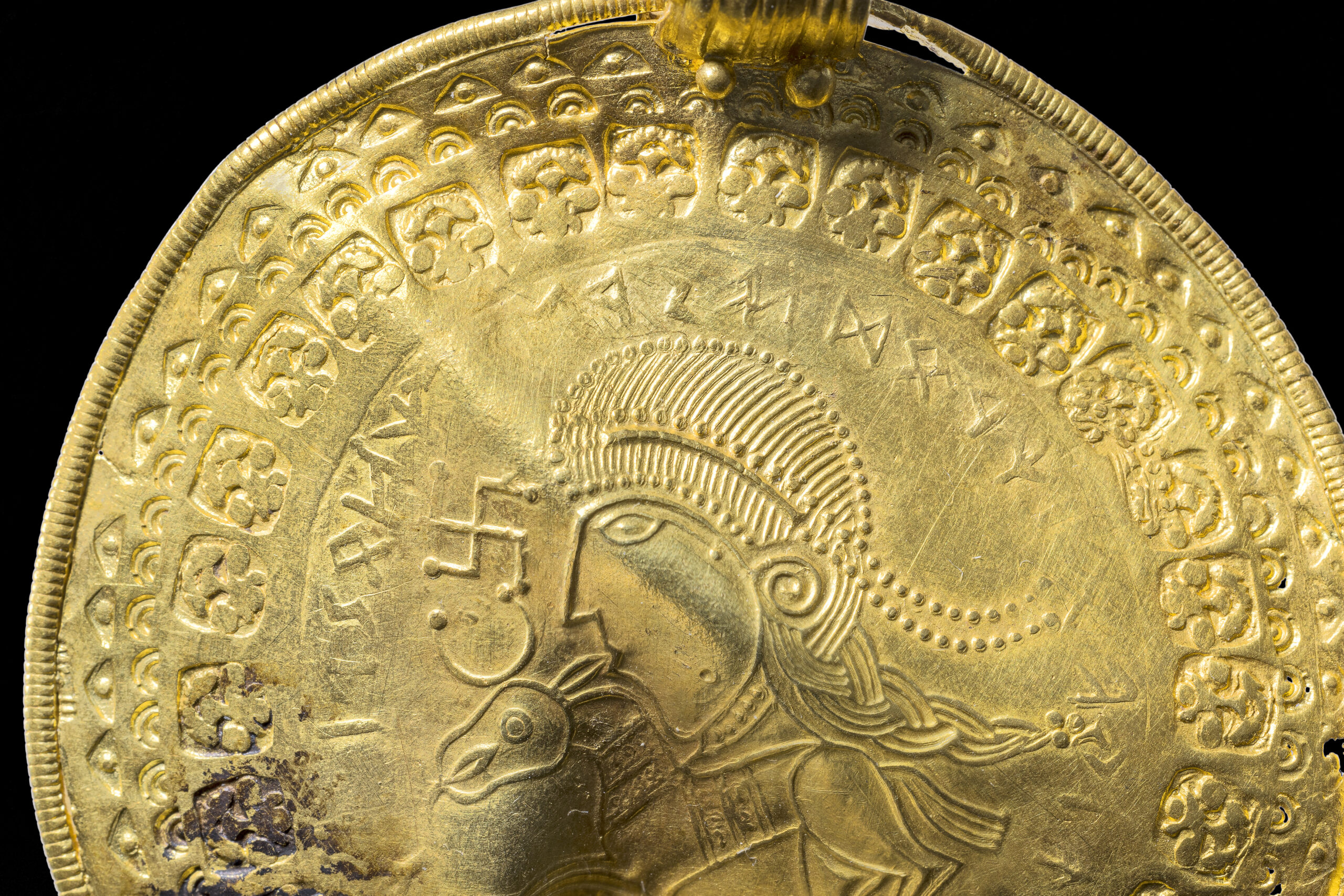 The inscription “He is Odin’s Man” is in a round half circle over the head of a man. Photo: Arnold Mikkelsen/The National Museum of Denmark.