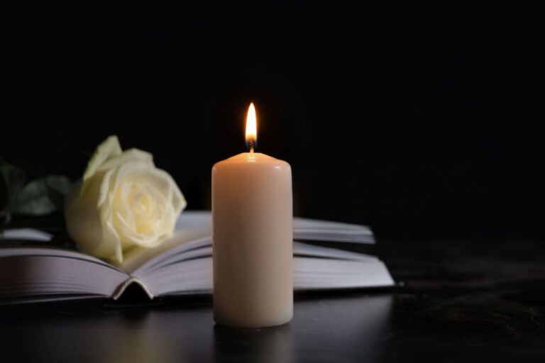 A prayer book, flower and candle.