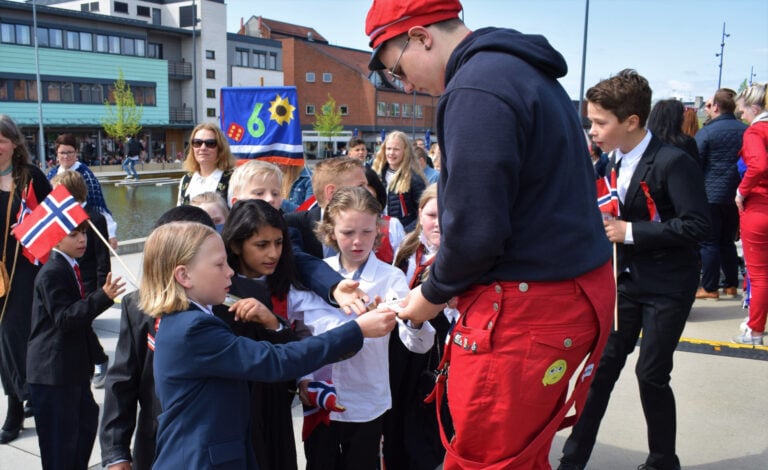 Russ giving out cards to younger children. Photo: SiljeAO / Shutterstock.com.