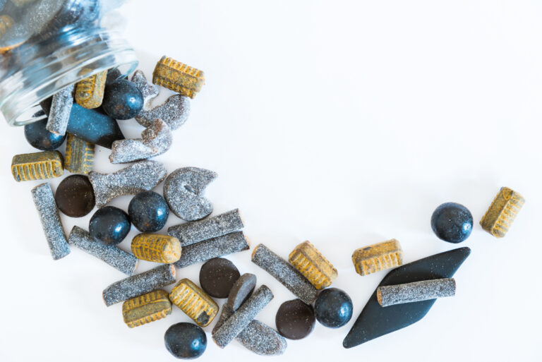 Empty jar of salty liquorice on a table.