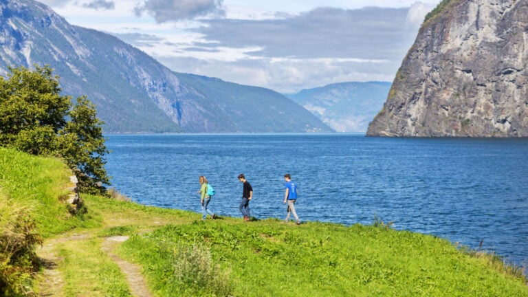 Group hiking along the banks of the Aurlandsfjord, Norway.