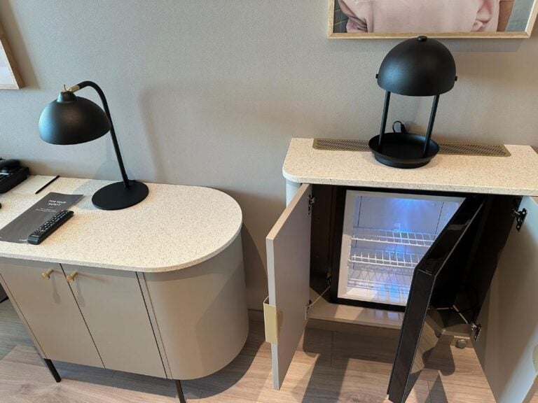 Mini-fridge and working desk in hotel room.