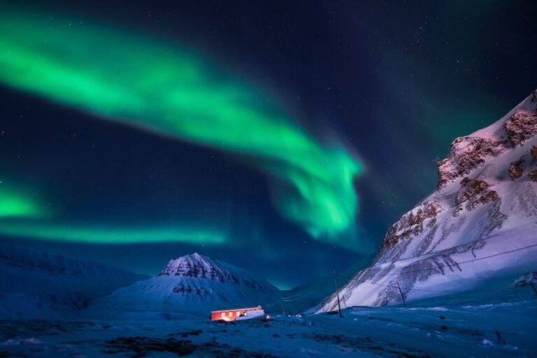 Longyearbyen in polar night with northern lights above.