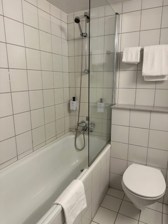 Guest bathroom in Scandic Drammen hotel featuring shower over bath.