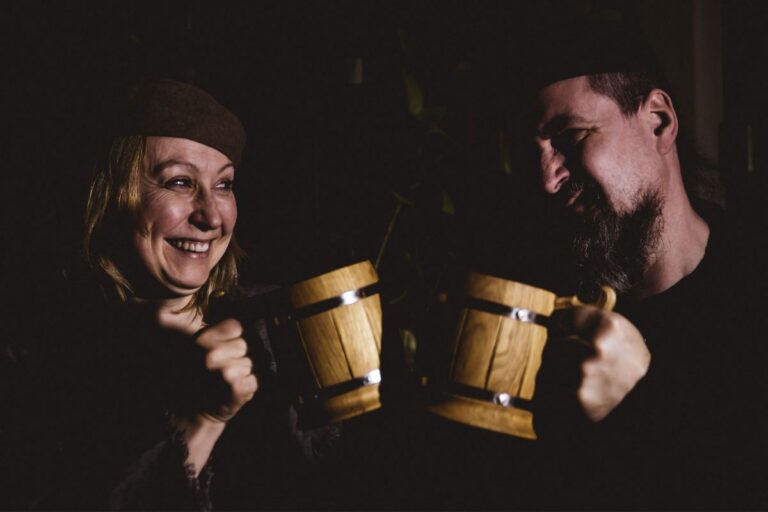 Two people dressed as Vikings offering a toast.