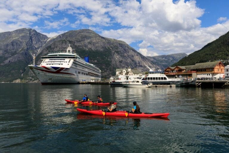 Tourists kayaking by P&O Aurora cruise ship in Eidfjord. Photo: Eleanor Scriven / Shutterstock.com.