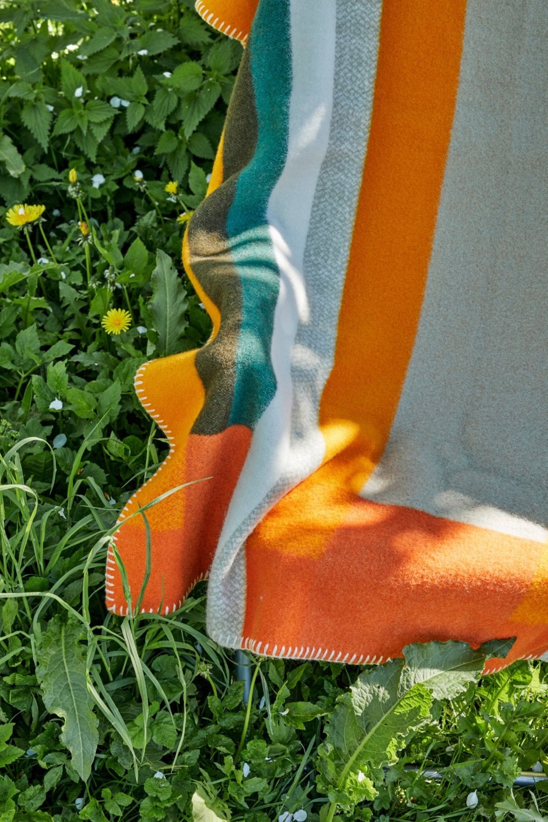 A blanket on a grassy field. Photo: Røros Tweed.