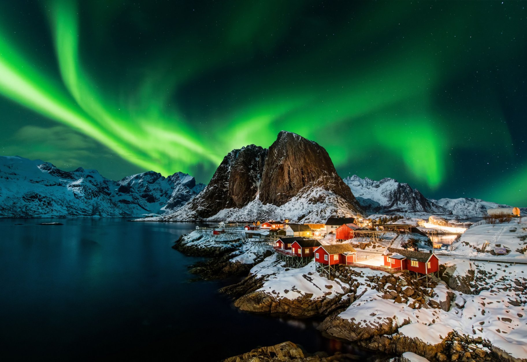 Lofoten in winter with northern lights above.
