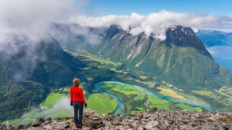 Hiker admires the Romsdal valley in Norway.