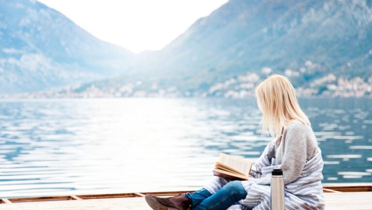 A girl reading a poem by a fjord in Norway.