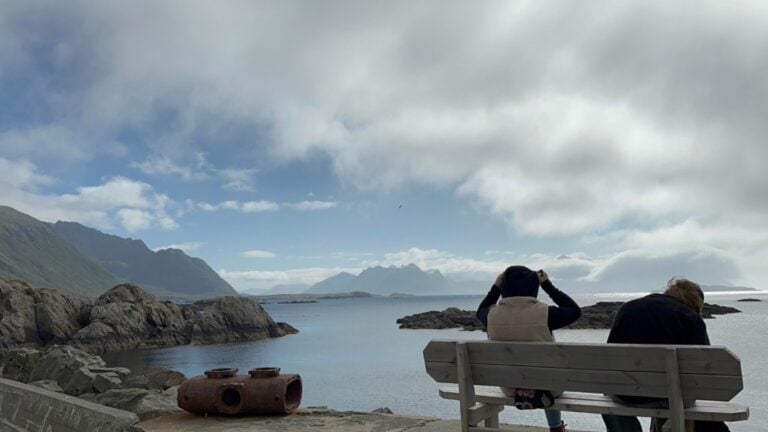 Two people sitting on a bench in Nyksund, Norway. Photo: David Nikel.