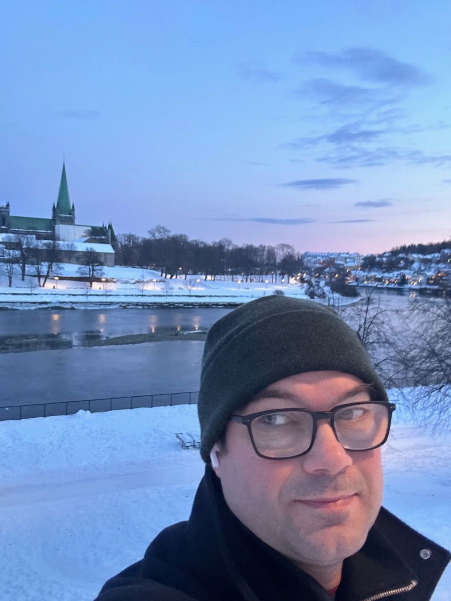 David Nikel by river and cathedral in Trondheim, Norway.
