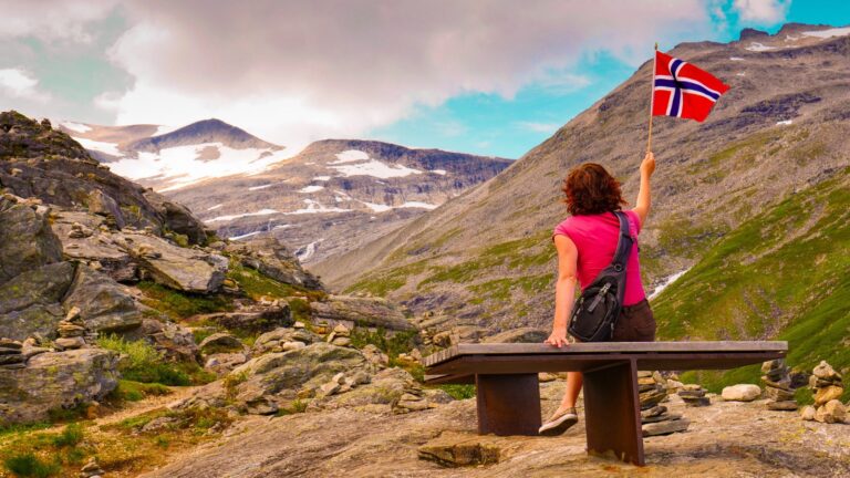 Norway hiker holding a Norwegian flag.
