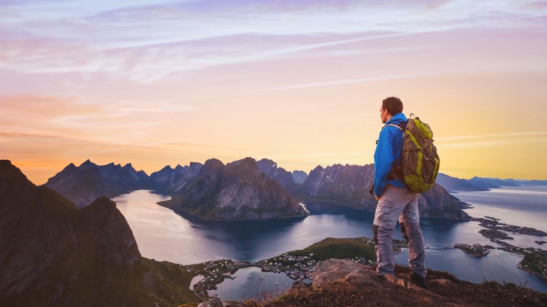 Hiker gazing out over spectacular scenery in Norway.