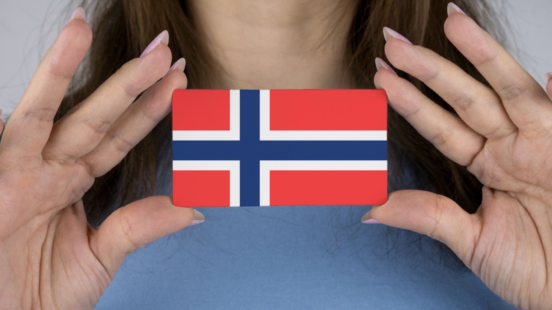 Female hands holding flag of Norway.