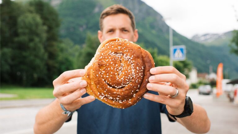 Man holding a Norwegian cinnamon bun in Norway.