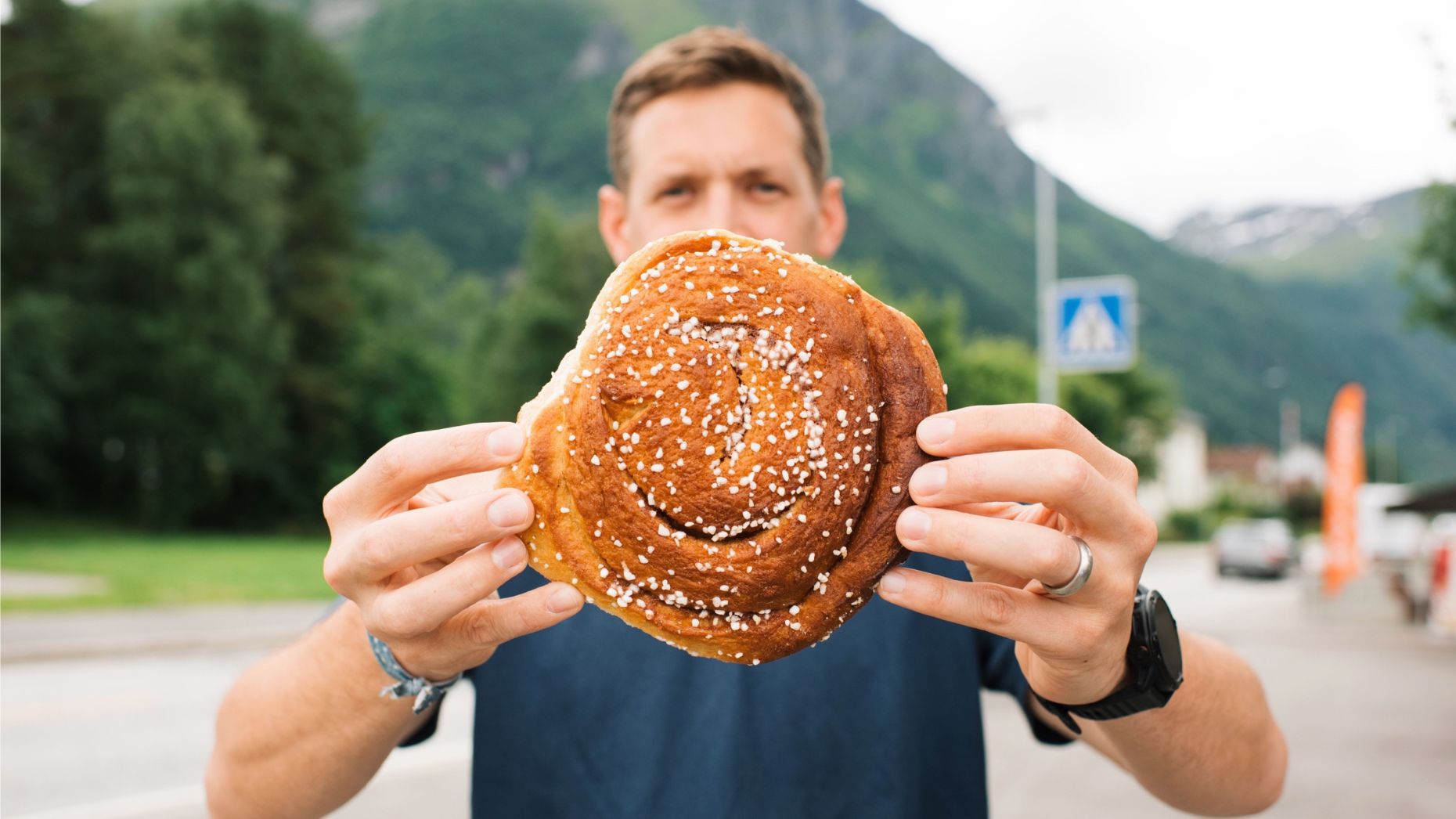 Man holding a Norwegian cinnamon bun in Norway.