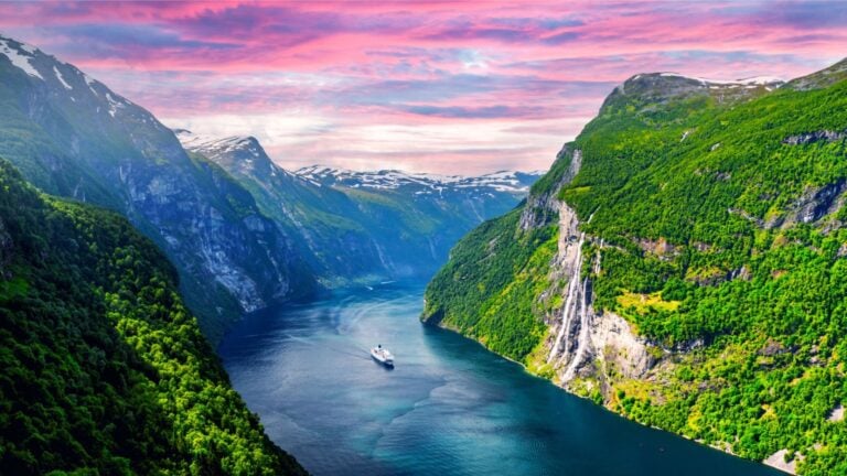 Norway fjord cruise with a pink sky.