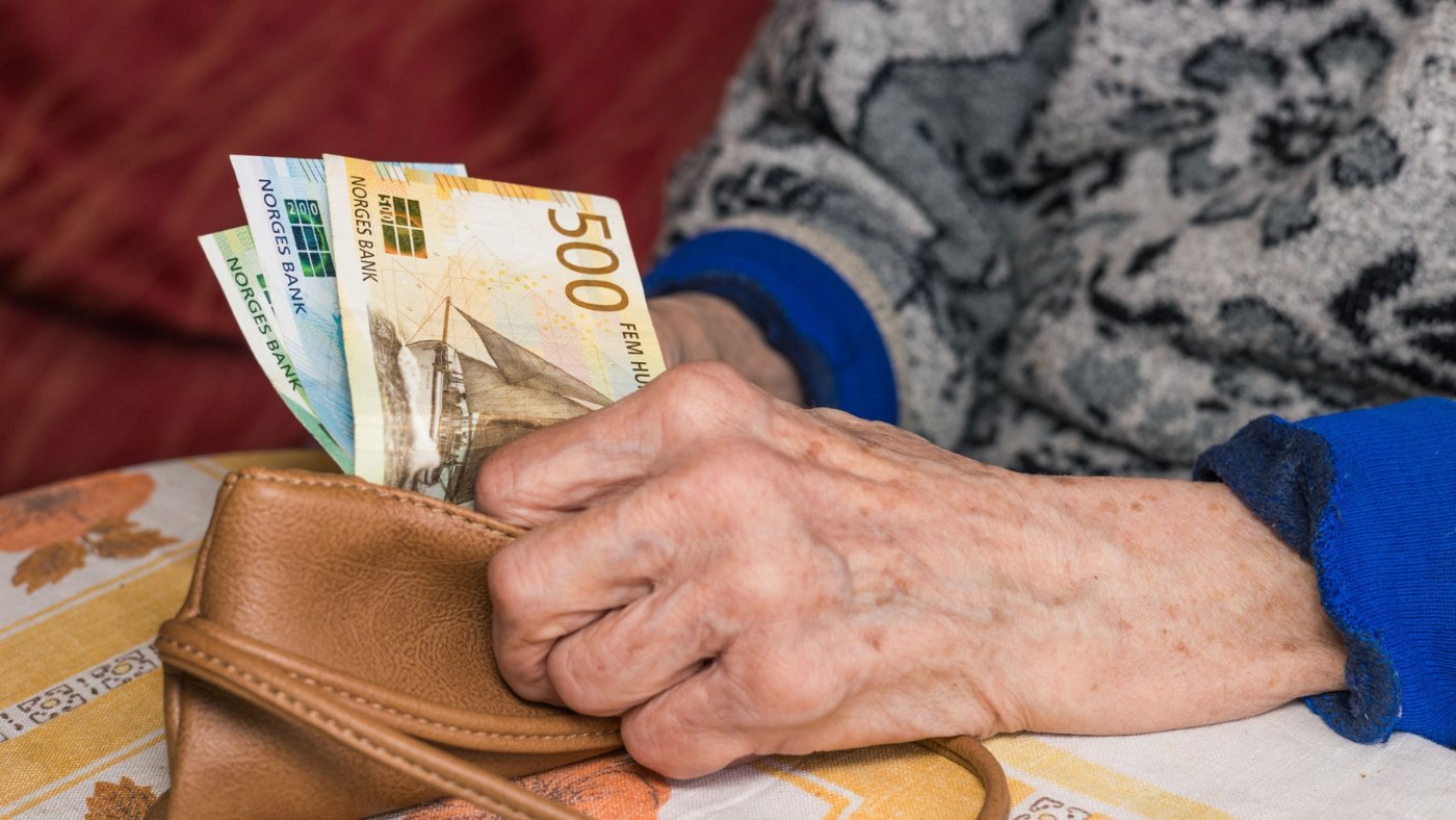 Norway banknotes in hand.