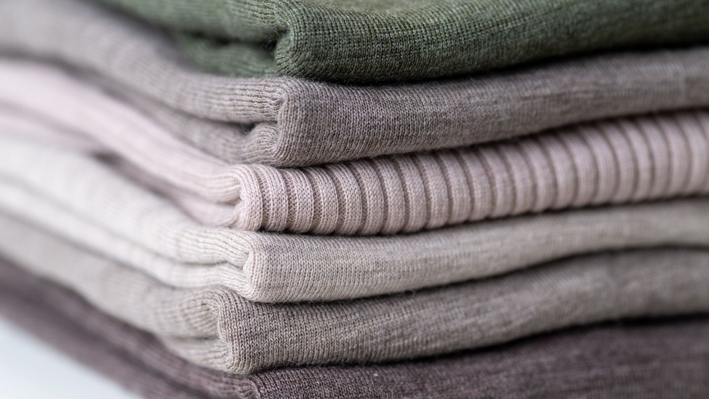 Pile of merino wool garments.